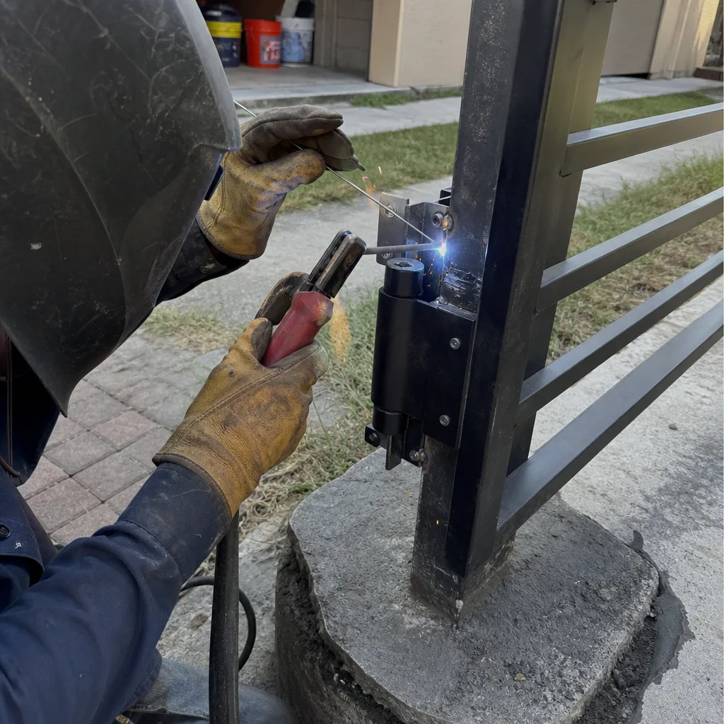 Professional welder performing metal gate repair and installation